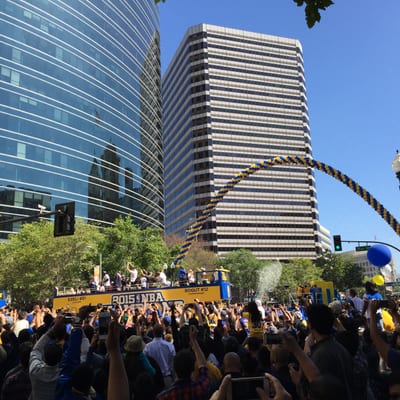 A championship parade celebration with crowds of fans gathered around buses