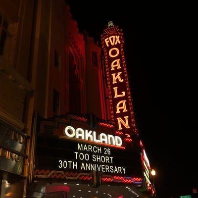 The iconic Fox Oakland Theater marquee glows with red neon lights against