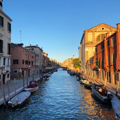A picturesque Venetian canal lined with colorful historic buildings in warm