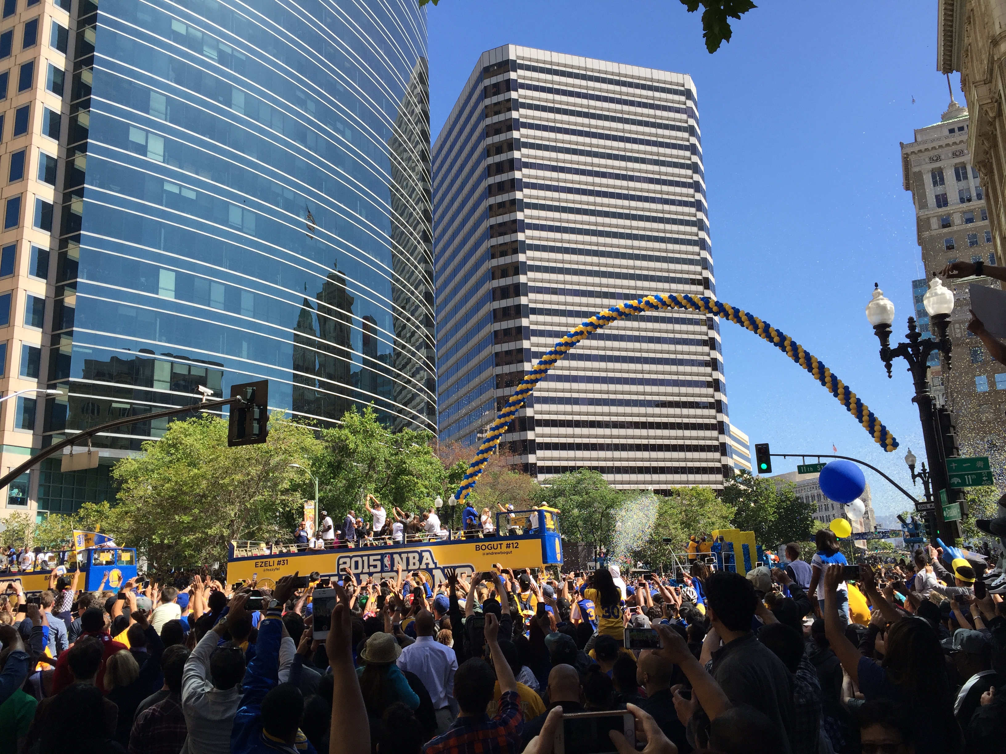 A championship parade celebration with crowds of fans gathered around buses