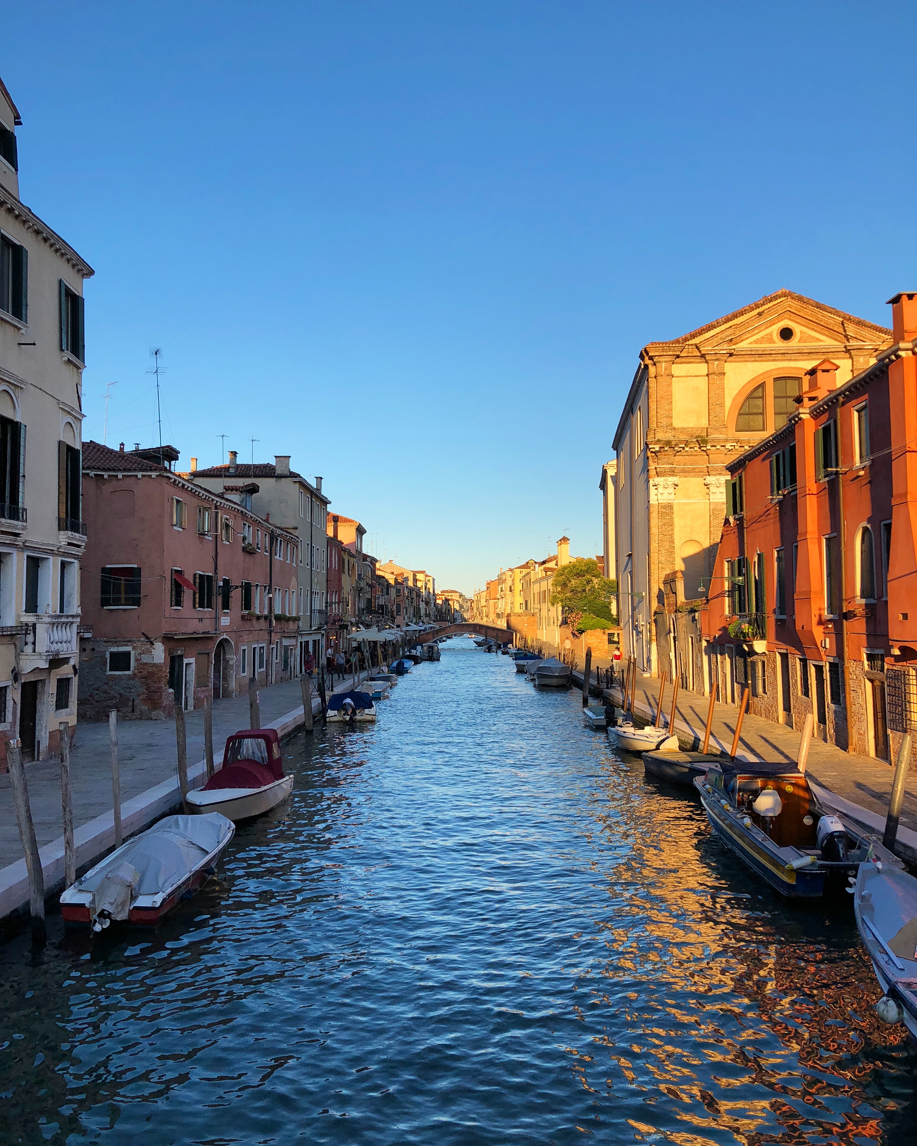 A picturesque Venetian canal lined with colorful historic buildings in warm
