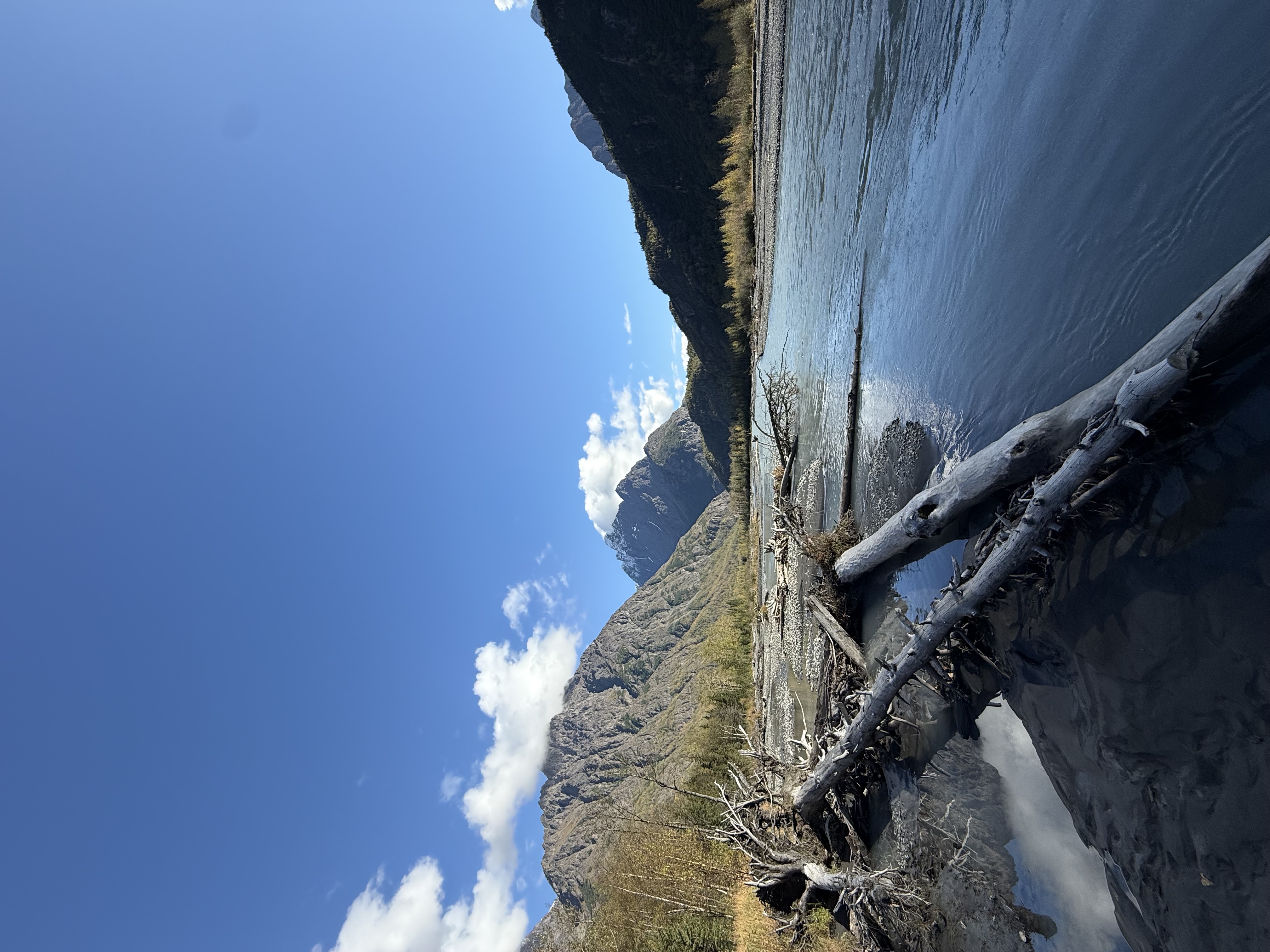 A river winds through a mountainous valley with snow-capped peaks under a